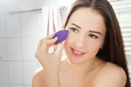 Woman applying foundation with beauty blender